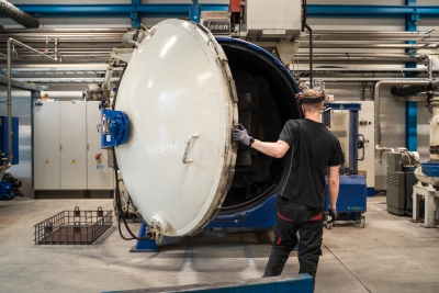 Asiantuntija tarkkailee modernissa vakuumiuunissa käsiteltäviä teräskomponentteja Stén-konsernin Muuramen yksikössä