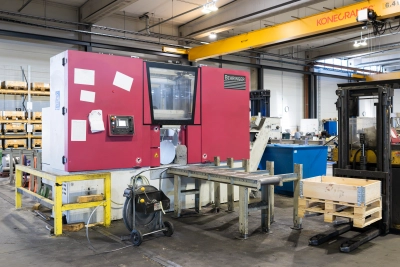 Behringer-saha Stén-konsernin teräspalvelukeskuksessa. Kuvassa näkyy automaattinen katkaisusaha, rullarata, trukki sekä tuotantotilaa taustalla.